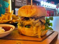 a sandwich on a wooden cutting board with french fries at El Jardín Escondido by Soma in Baños