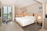 a bedroom with a large white bed and a balcony at Sheraton Abu Dhabi Hotel & Resort in Abu Dhabi