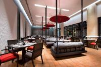 a restaurant with tables and chairs and chandeliers at Le Meridien Chiang Rai Resort, Thailand in Chiang Rai
