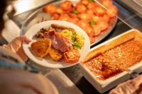 una persona sosteniendo un plato de comida en un mostrador en Sarum College, en Salisbury