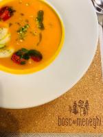 een wit bord met een kom soep op een tafel bij Bosc del Meneghì in Ledro