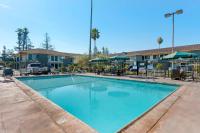 a large blue swimming pool with tables and chairs at Sonoma Winegrower&#39;s Inn in Rohnert Park