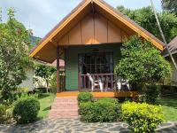 a green house with two white chairs on the porch at Koh Chang Bailan Beach Resort in Ko Chang