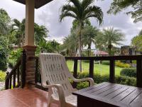 a white chair sitting on a porch with a table at Koh Chang Bailan Beach Resort in Ko Chang
