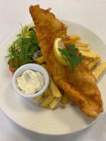 a plate of fish and french fries with a side of sauce at The Popinjay Hotel in Larkhall