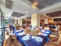 uma sala de jantar com uma mesa e cadeiras azuis em Poulo Wai Hotel, Trademark Collection by Wyndham em Phnom Penh