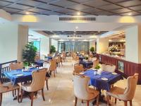 uma sala de jantar com mesas e cadeiras azuis em Poulo Wai Hotel, Trademark Collection by Wyndham em Phnom Penh