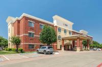 Un edificio con un coche aparcado en un estacionamiento. en Comfort Suites McKinney-Allen, en McKinney