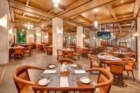 un ristorante con tavoli e sedie in legno e una televisione di Pearl Continental Hotel Malam Jabba a Swat