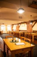 Un comedor con mesa y sillas de madera. en Pension U Kohoutů, en Horní Planá