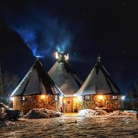 Un edificio con nieve en sus techos por la noche. en KOZAK Apartments & Restaurant, en Mojkovac