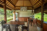 Pondok Hari Baik في Balian: منطقة طعام مع طاولات وكراسي في الجناح