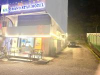 Un coche aparcado fuera de un gran hotel de estrellas por la noche. en Grand Star Hotel, en Batu Ferringhi