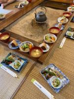 uma mesa com pratos de comida e tigelas de comida em GAMP HOUSE がんぷはうす 江戸農家古民家ホステル Old Folk Farm Hostel em Iwaki