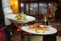 a person holding a plate of food with a salad and bread at Hotel Iconic Suite - Near Delhi Airport in New Delhi