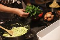 a person preparing food in a pan on a counter at Domaine Foray in Villecien