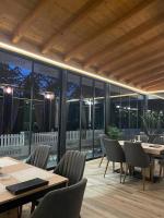 een restaurant met tafels en stoelen en grote ramen bij Restoran Motel Kanjon in Skender Vakuf