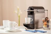 a toaster sitting on a table with cups and a glass at NH Frankfurt Messe in Frankfurt
