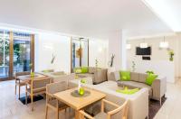 a living room with a couch and tables and chairs at NH Frankfurt Messe in Frankfurt