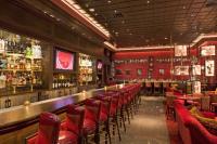 a restaurant with a bar with red chairs and tables at Planet Hollywood Resort & Casino in Las Vegas