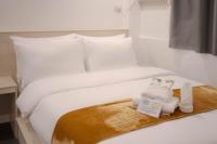 a bed with a tray with two towels on it at A Traveller&#39;s Inn in Daraga