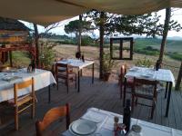 een houten terras met tafels en stoelen op een patio bij Agriturismo La Terra in Valiano