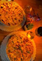 Duas pizzas em cima de uma mesa de madeira em Maison du sud hotel em Ibil es-saqi