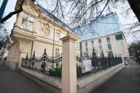 a building with a fence in front of a building at Wilson Palace by LOFT in Bratislava