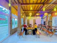 Dos mujeres sentadas en una mesa en un restaurante en Tom-House Mai Châu, en Bản Bang