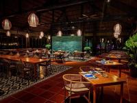 a restaurant with wooden tables and chairs and a chalkboard at Vinpearl Resort & Spa Phu Quoc in Phú Quốc