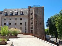 un edificio con una torre alta junto a un edificio en Hôtel Tour Maje, en Rodez