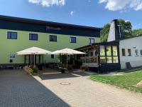 Gemütliche Ferienwohnung in idyllischer Lage-auf dem Land في Dittersdorf: مبنى أخضر فيه مظلتين أمامه