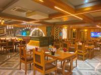 een restaurant met tafels en stoelen en een bar bij Blue Diamond Resort & Hotel in Muzaffarpur