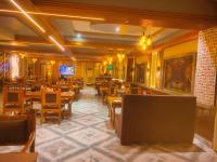 een restaurant met houten tafels en stoelen in een kamer bij Blue Diamond Resort & Hotel in Muzaffarpur