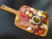 een houten snijplank met vlees, kaas en groenten bij Le Fin Chapon in Excideuil