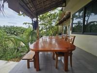 una mesa de madera y sillas en el porche de una casa en InnerZen Riverside homestay Ben Tre 1 bedroom for 1-2 guests, 2 bedrooms for 3-4 guests, en Ấp Phú Hòa (3)