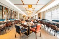 ブリンダーバンにあるRadisson Hotel Vrindavanのテーブルと椅子のあるダイニングルーム