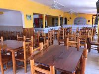 Un comedor con mesas y sillas de madera. en Hotel y Balneario San Fernando, en Ojuelos