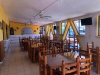 Un comedor con mesas y sillas de madera. en Hotel y Balneario San Fernando, en Ojuelos