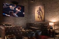 詹姆斯敦Chicken Ranch Casino Resort的房间里有一张沙发，墙上挂着一幅篮球的图片。