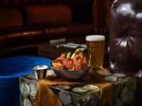 詹姆斯敦Chicken Ranch Casino Resort的桌子上放着一碗食物和一品脱啤酒。