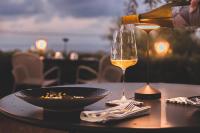 チェファルにあるVilla Totò Resortのワインをテーブルの上に注ぐ者