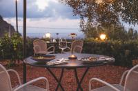 チェファルにあるVilla Totò Resortのワイングラスと椅子が置かれたテーブル