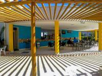 eine Terrasse mit Tischen und Stühlen und einer blauen Wand in der Unterkunft Lagoa Quente Flat in Caldas Novas