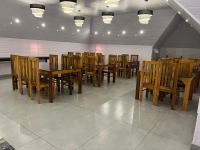 a dining room with wooden tables and chairs at The Windy Mist Resort Munnar in Chinnakanal