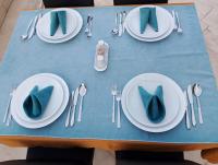 ein Tisch mit weißen Tellern und Silberbesteck mit blauen Servietten in der Unterkunft BALŞEN HOTEL in Anamur
