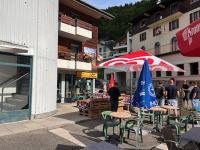 un groupe de tables et de chaises avec des parasols dans une rue dans l'établissement Auberge le bois du cornet, à La Forclaz