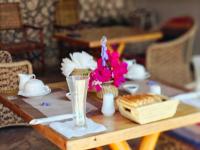 南威Nungwi Roses的一张木桌上摆放着鲜花和一盘食物。