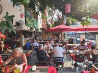 a group of people sitting at tables in a restaurant at Patumnak Beach Guesthouse in Pattaya South