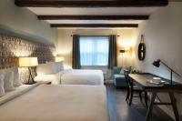 Una habitación de hotel con dos camas y un escritorio. en The Century House, an Ascend Collection Hotel, en Latham